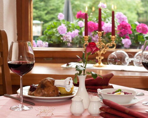 Gedeckter Tisch im Waldhotel Rennsteighof mit Rotwein, Gänsekeule und Thüringer Klößen
