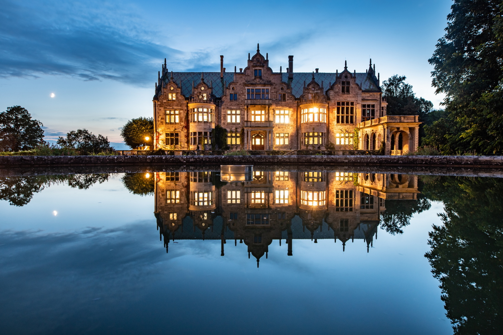 Abendaufnahme beleuchtetes Schloss Altenstein mit Wasserspiegelung